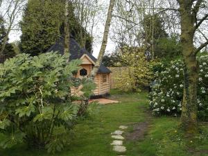 ein kleines Holzhaus in einem Garten mit Hof in der Unterkunft KOTA Finlandais ETRETAT in Les Loges