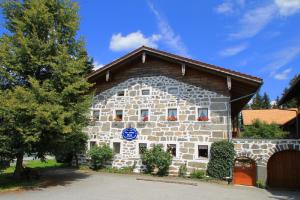 ein großes Steingebäude mit einem blauen Schild darauf in der Unterkunft Landurlaub bei Familie Haug in Freyung