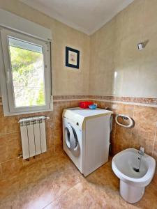 a bathroom with a washing machine and a sink at Apartamentos La Capitana in Luarca +76 photos