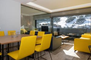 uma sala de jantar com uma mesa e cadeiras amarelas em THE MIRROR & SPA by Elegant Residences em Ransol