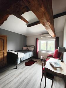 een slaapkamer met een bed en een tafel en stoelen bij Chambres d'hôtes - Les Varennes in Saint-Georges-de-Reneins