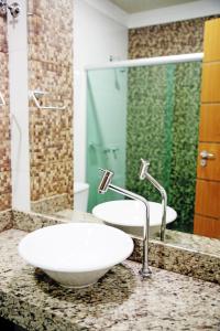 a bathroom with two sinks and a shower at Hotel Vale Do Xingu in Altamira