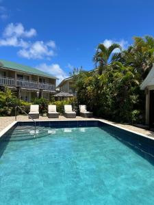 a swimming pool with two chairs and a house at Harmony Marina Suites in Rodney Bay Village