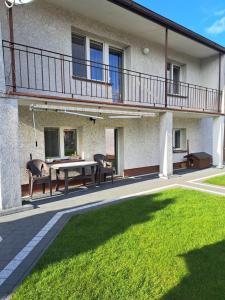 a patio with a table and chairs in front of a building at Pod czereśniami in Tolkmicko