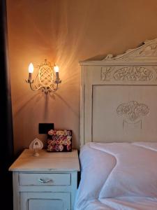 a bedroom with a white bed and a nightstand with a lamp at Mister Barolo Apartments Langhe in Novello +37 photos