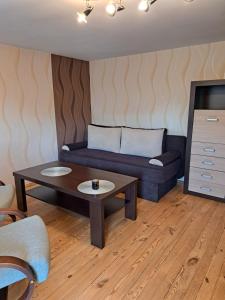 ein Wohnzimmer mit einem Sofa und einem Couchtisch in der Unterkunft Pod czereśniami in Tolkmicko