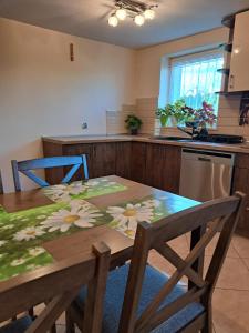 a kitchen with a wooden table with flowers on it at Pod czereśniami in Tolkmicko