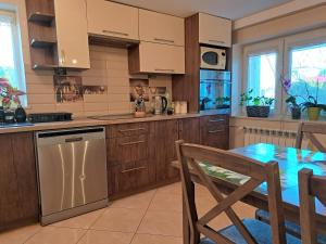 a kitchen with wooden cabinets and a table and a dining room at Pod czereśniami in Tolkmicko