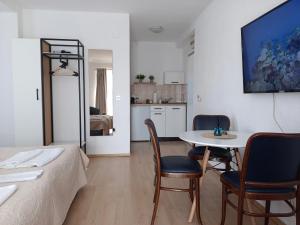 Cette chambre comprend un lit, une table et des chaises. dans l'établissement Apartments Gugoski, à Ohrid