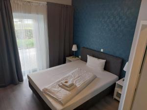 CASILINO Hotel A 20 Wismar في فيسمار: غرفة نوم بسرير مع جدار ازرق