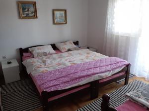 a bedroom with a bed with a purple comforter at La Hacienda DD in Trebinje