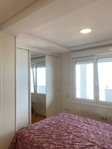 een slaapkamer met een bed en 2 ramen bij LA SANADORA in Almería