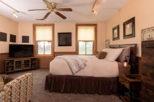 a bedroom with a bed and a flat screen tv at Riverboat Suites in Galena