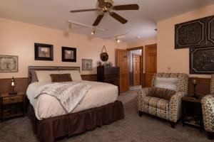 1 dormitorio con 1 cama, ventilador y silla en Riverboat Suites, en Galena