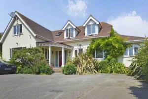 a white house with a car parked in front of it at Broadway Pool House with Sauna & Jacuzzi in Herne Bay