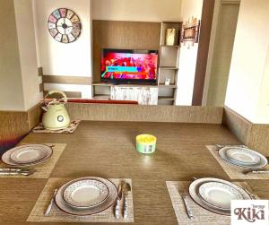 a table with plates and a tv in a room at Kiki Home in Blagoevgrad
