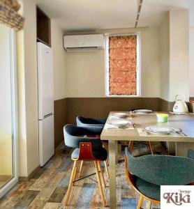 een keuken met een tafel, stoelen en een koelkast bij Kiki Home in Blagoevgrad