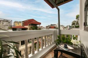 a balcony with a table and a view of a city at La Renta Hotel & Spa in Hanoi