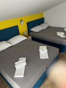 two beds in a room with towels on them at Guesthouse Villa Jurišić in Novalja +41 photos