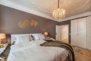 a bedroom with a large white bed with a chandelier at PASSAU mittendrin in Passau
