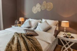 una camera da letto con letto, lenzuola e cuscini bianchi di PASSAU mittendrin a Passavia