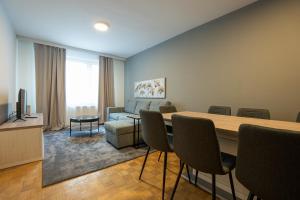 een woonkamer met een tafel en stoelen en een bank bij A spacious 3-bedroom apartment with king-size beds is located within 5 minute’s walk from the Prater in Wenen