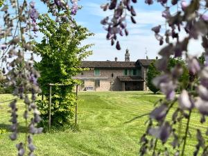 a house in a field with a tree in the foreground at da Luigi al Mulino in Annicco