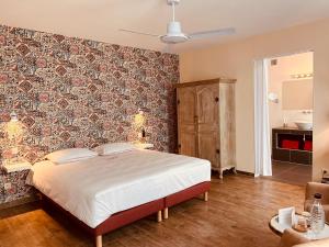 a bedroom with a bed and a wall covered in wallpaper at Hotel Het Heilig Genot in Westvleteren