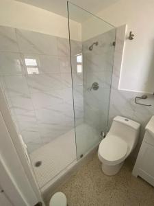 a white bathroom with a shower and a toilet at 2 Min Walk To The Beach-all Renovated Studio #4 in Fort Lauderdale