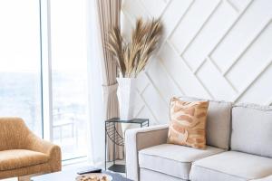 The bright One Residence by Suiteable Interiors في دبي: غرفة معيشة مع أريكة وكرسي