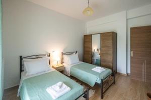 a bedroom with two beds and a mirror at Elpida's country house in Lefkimmi