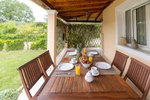 a wooden table with chairs and plates of food on it at Elpida's country house in Lefkimmi
