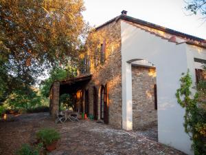 - une vue extérieure sur un bâtiment en pierre avec une arche dans l'établissement Casa Poggio Agliai basso, à Suvereto