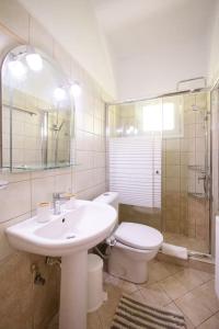 a bathroom with a sink and a toilet and a shower at Elpida's country house in Lefkimmi +36 photos