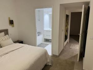 biała sypialnia z łóżkiem i łazienką w obiekcie Horizon Bay - Pool - Fitness Room - Terrace w Cannes