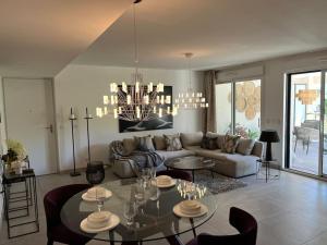 salon z kanapą i żyrandolem w obiekcie Horizon Bay - Pool - Fitness Room - Terrace w Cannes