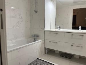 biała łazienka z wanną i umywalką w obiekcie Horizon Bay - Pool - Fitness Room - Terrace w Cannes