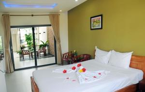 a hotel room with a bed with flowers on it at Melody Boutique Villa Hoi An in Hoi An