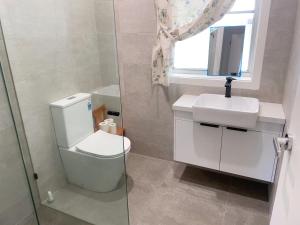a bathroom with a toilet and a sink and a window at Comfy Private rooms in Braybrook in Braybrook