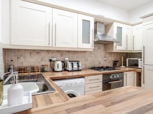 a kitchen with white cabinets and a sink at Pass the Keys Serenity in the Suburbs - Modern 2BR Apartment in Liverpool