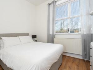 ein Schlafzimmer mit einem großen weißen Bett und einem Fenster in der Unterkunft Pass the Keys Serenity in the Suburbs - Modern 2BR Apartment in Liverpool