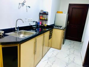 a kitchen with a sink and a refrigerator at بورتو سعيد غرفه وصاله ارضى in `Ezbet Shalabi el-Rûdi