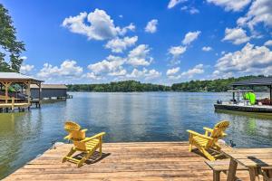 a dock with two chairs and a table on a lake at Lakefront Eatonton Getaway with Dock and Grill! in Resseaus Crossroads