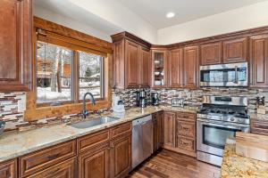 una cucina con armadietti in legno ed elettrodomestici in acciaio inossidabile di Cherry Drive home a Steamboat Springs