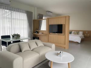 Karisma Private Villa Pattaya في جومتين بيتش: غرفة معيشة مع أريكة وسرير