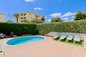 een zwembad in een tuin met stoelen en een heg bij Villa Molgard 61 - Clever Details in Vilamoura