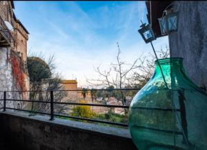 a green glass vase sitting on a window sill at Giamevi House in Vignanello