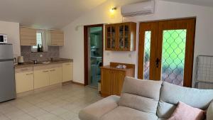 een woonkamer met een bank en een keuken bij Apartment Murva in Premantura