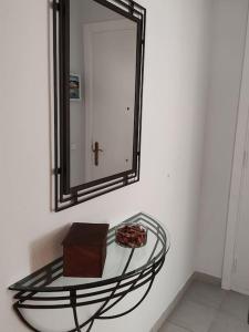 una mesa de cristal con un espejo en la pared en Apartmento Duplex, en S'Agaró
