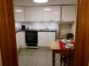 a kitchen with white cabinets and a wooden table with a tableablish at Triplex près de la Grand-Place in Brussels +15 photos